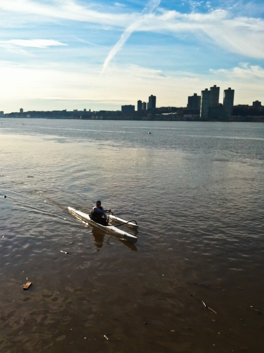 An outrigger canoe paddler heads down the Hudson River during the summer. (Charlotte Cuthbertson/The Epoch Times)