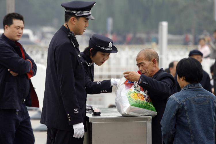 A policewoman checks a man's bag on Tiananmen Square in Beijing ahead of the 17th National Congress of the Communist Party of China in October 2007. Intense security measures are already in place for next month's Beijing Olympics. (Peter Parks/Getty Images)