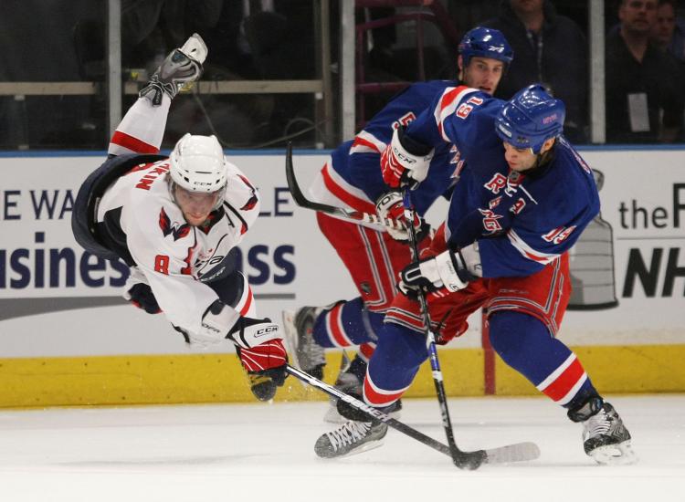 WHAT IT TAKES: Alex Ovechkin goes airborne in a battle for the puck with Scott Gomez.  (Bruce Bennett/Getty Images)