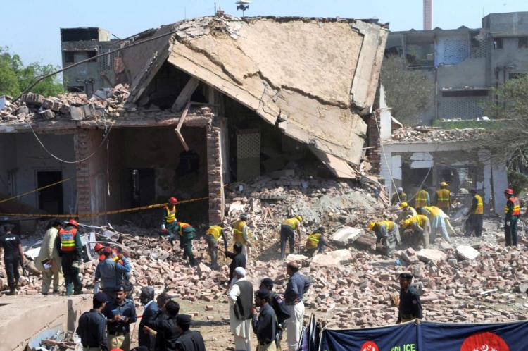 Pakistani volunteers search for blast victims in the rubble of the destroyed law enforcement building on Monday. (Arif Ali/AFP/Getty Images)