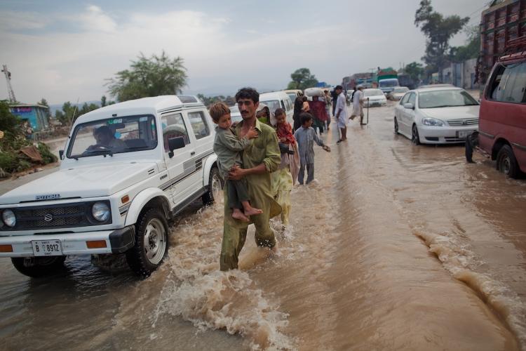 Local residents travel down a flood affected road on August 1,  in Nowshera, Pakistan. Rescue workers and troops in northwest Pakistan struggled to reach thousands of people affected by the country's worst floods since 1929.   (Daniel Berehulak/Getty Images)