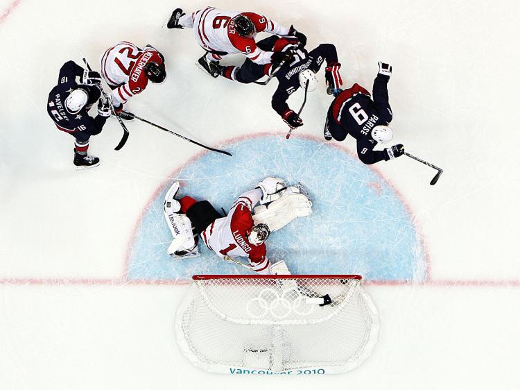 Zach Parise #9 of the United States puts a loose puck past a sprawled Roberto Luongo of Canada, forcing overtime in the men's gold-medal hockey game. (Bruce Bennett/Getty Images)