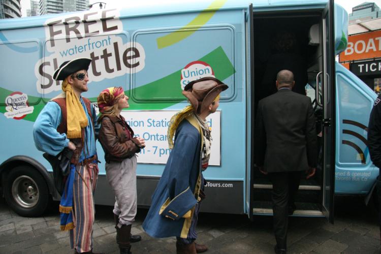 A gang of pirates roam around the shuttle bus, inviting people to join them at the waterfront on Victoria Day. (Lina Berezovska/The Epoch Times)
