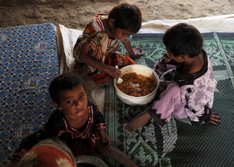 Pakistani children, displaced by floods, eat food at a makeshift camp in Karachi.  (Asif Hassan/AFP/Getty Images)