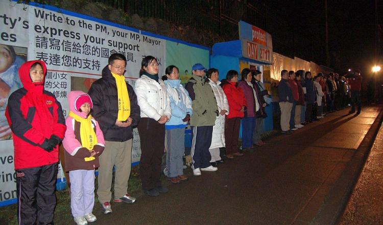 Falun Gong practitioners stand by the blue hut at the protest site the group maintained outside the Chinese consulate on Granville St. from 2001 to 2009. (The Epoch Times)