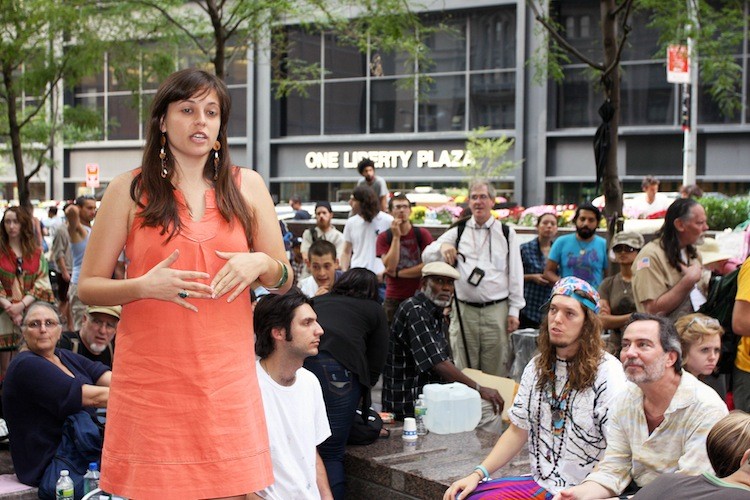 Talia Hagerty, a Global Affairs and Peacebuilding student at New York University who has been studying nonviolent social change and is documenting Occupy Wall Street, spoke to the crowd at Zuccotti Park near Wall Street on Monday. (Zack Stieber/The Epoch Times)