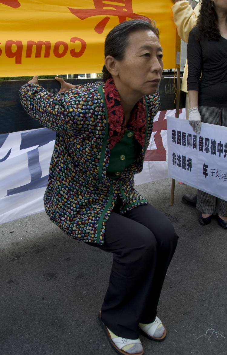DEMONSTRATING TORTURE: Across the street from the Waldorf Astoria on Monday, Falun Gong practitioner Zhen Jie Yu demonstrates the torture she was subjected to by communist authorities in China. Chinese leader Hu Jintao is staying in the hotel ahead of the (Aloysio Santos/The Epoch Times)
