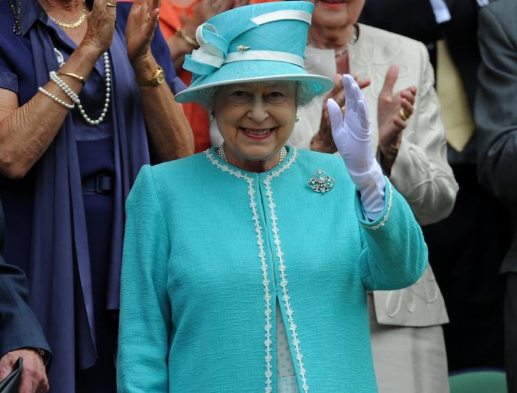 Her Majesty Queen Elizabeth II waves as she attends the Wimbledon Tennis Championships on June 24. The Queen and her husband, the Duke of Edinburgh, begin a nine-day tour of Canada on June 28.  (Adrian Dennis/Getty Images)