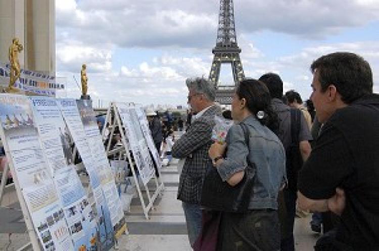 Tourists from all over the world reading the signs at the Paris Human Rights Square. (The Epoch Times)