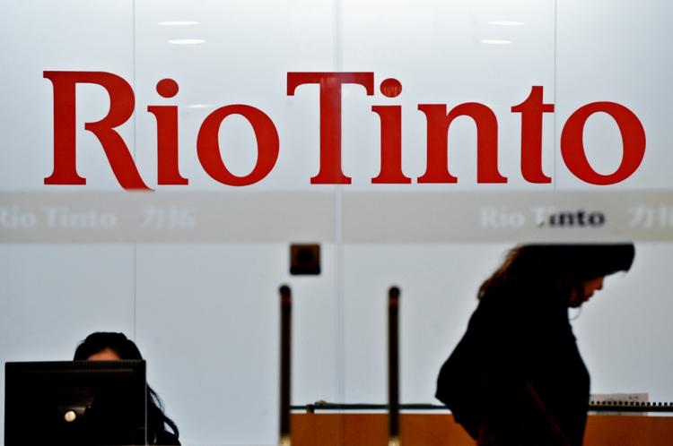 An employee of Australian mining giant Rio Tinto walks past a sign at the Shanghai offices of the firm on February 11, 2010. Australia urged China to hold a quick and open trial for Rio Tinto mining executive Stern Hu, who was formally charged with industrial espionage seven months after his arrest. (Philippe Lopez/AFP/Getty Images)