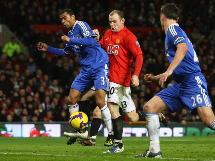 OPENING GOAL:Wayne Rooney (center) manages to get a foot on the ball to score as Ashley Cole (left) tries to clear it. (Alex Livesey/Getty Images)