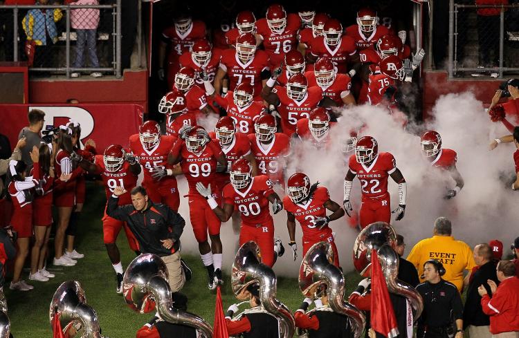 In this file photo, head coach Greg Schiano of the Rutgers Scarlet Knights leads his team onto the field to play against the Connecticut Huskies. Rutgers's player Eric LeGrand was injured and paralyzed after a tackle during a weekend game against Army. (Jim McIsaac/Getty Images)