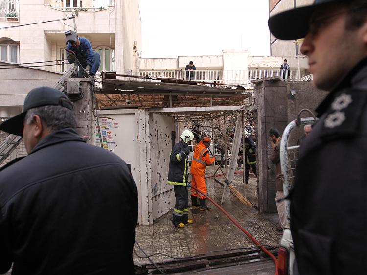 Iranian security guards, firemen and municipality workers are observe the scene of a remote-controlled bomb explosion in which Professor Massoud Ali Mohammadi was killed outside his Tehran residence on January 12, 2010. (AFP/Getty Images)