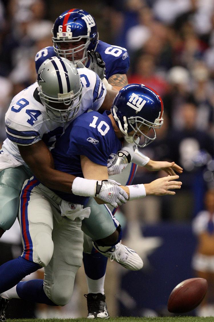 SACKED: DeMarcus Ware #94 of the Dallas Cowboys beats Giants tackle David Diehl #66 and sacks Eli Manning on the first play of the game.  (Ronald Martinez/Getty Images)