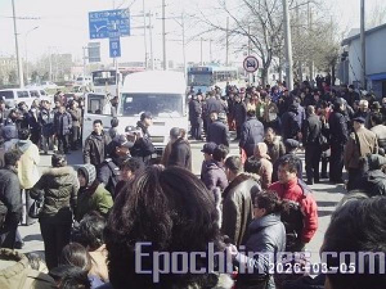 A young girl was brutally beaten at the Beijing Southern Train Station by police who were attempting to stop appellants. Over one thousand angered on-lookers surrounded and beat police, and smashed their car. (The Epoch Times)