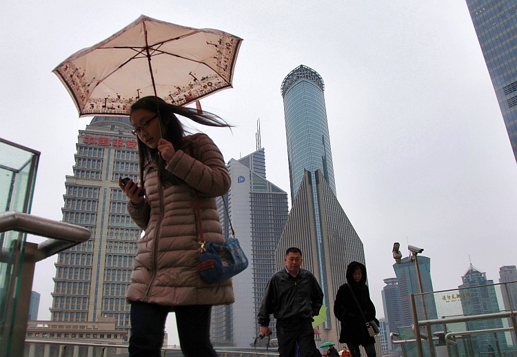 Pedestrians walk through the Lujiazui Financial District in Shanghai