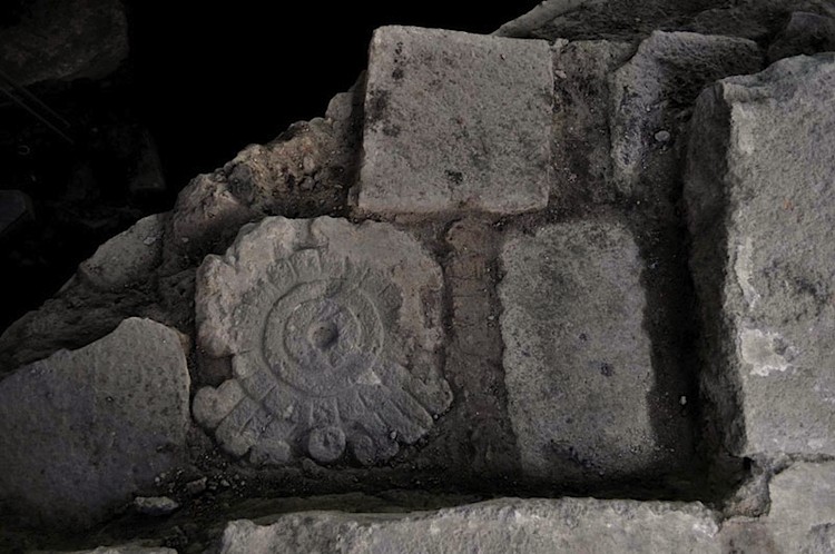 A stone tablet carved with scrolls resembling smoke. (INAH)