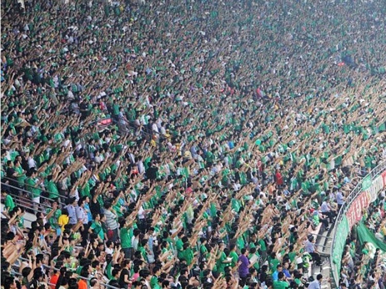 Fans at Beijing Worker's Stadium point their index fingers to the sky in a silent act of mourning, on Aug. 1 prior to a match between Beijing Guoan and Guangzhou GAC. (Weibo.com)