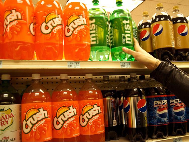 SODA TAX: A New Yorker reaches for a bottle of soda at a store in Midtown Manhattan on Tuesday. Governor David Paterson's proposed budget would add a 12 cent tax on cans of soda. (Jack Phillips/The Epoch Times)