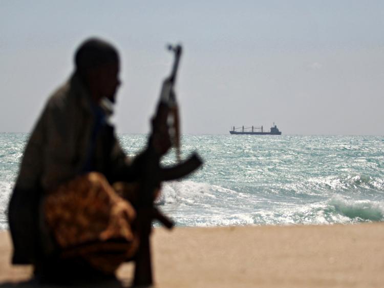 Armed Somali pirate along the coastline on Jan. while the Greek cargo ship, MV Filitsa, is seen anchored just off the shores of Hobyo town in northeastern Somalia. (Mohamed Dahir/AFP/Getty Images)