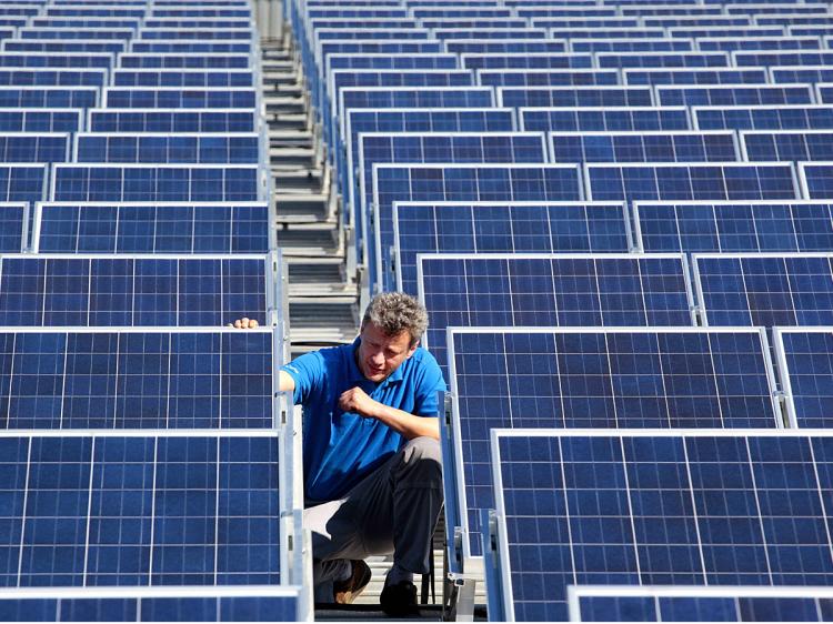 A technician checks the panels of a solar power system. Green energy technicians will be in demand as alternative energy is replaces fossil fuels. (Michael Urban/AFP/Getty Images)