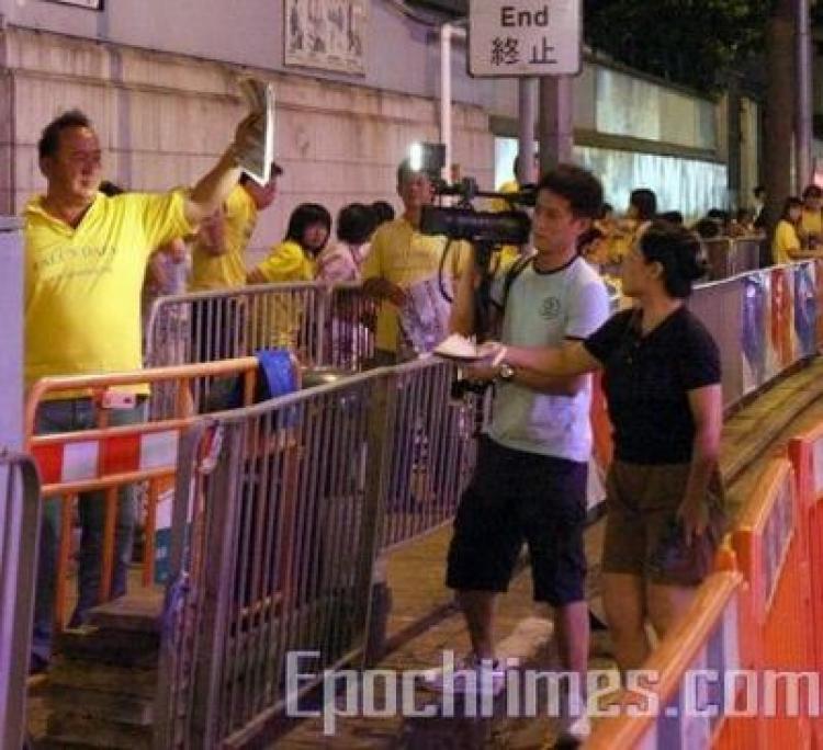 The alleged spy (holding camera) insisted on filming every Falun Gong practitioners in the activities even after being asked not to. (The Epoch Times)