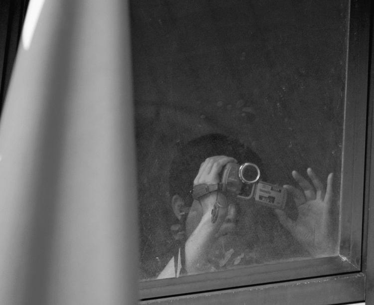 An employee of China's consulate in Rio de Janeiro, Brazil, records from a window a protest in front of the consulate on March 26, 2008. An espionage incident only weeks prior to chancellor Angela Merkel's planned China visit may be threatening the bilateral relations between Berlin and Beijing said German news magazine Spiegel Online in a June 26 article. (Antonio Scorza/AFP/Getty Images)