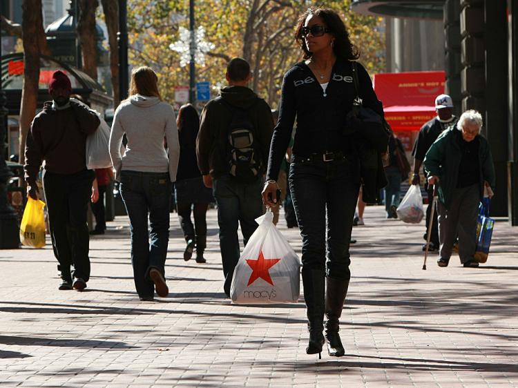 A shopper carries a bag from Macy's as she walks down Market Street in San Francisco, California.    (Justin Sullivan/Getty Images)