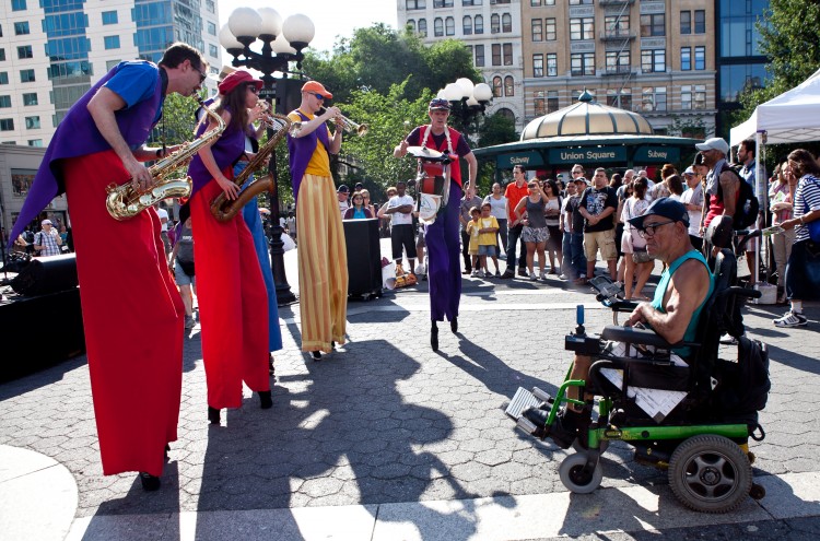 STANDING TALL: The Shinbone Alley Stilt Band surprises onlookers with their eclectic mix of wit, music, and tricks at Union Square on Thursday. (Amal Chen/The Epoch Times)