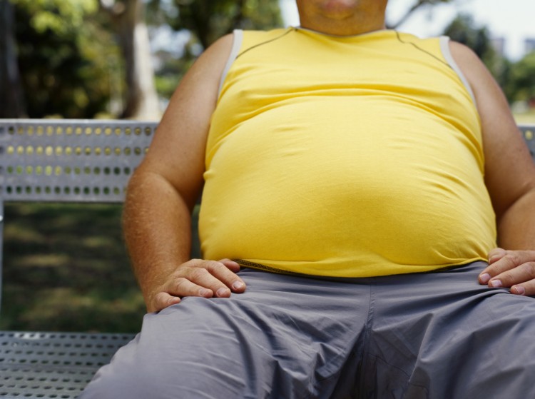 mid section view of a man sitting on a bench in a park