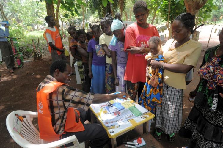 Sudanese voters listen to the instructions of a polling staff member at a voting station in the outskirts of the south-central town of Yambio in southern Sudan on April 12. Sudan's national election commission said it was extending voting for two days after logistical problems marred the beginning of the country's first competitive elections in 24 years.  (Roberto Schmidt/AFP/Getty Images)