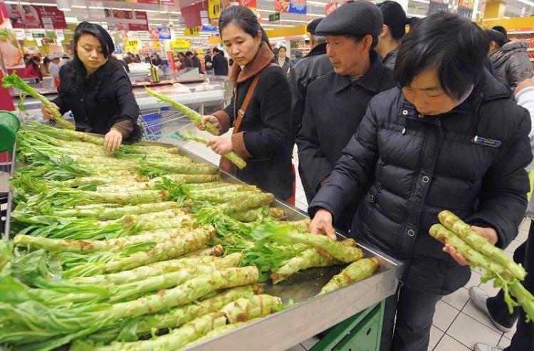 Customers check vegetable prices at a supermarket in Hefei City, Anhui Province, on April 13. (AFP/Getty Images)