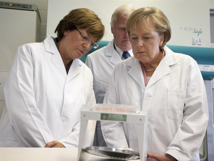 German Chancellor Angela Merkel (R) and German Health Minister Ulla Schmidt visit together with Robert Koch Institute vice president Reinhard Burger (back) the Robert Koch Institute on June 23, 2009 in Berlin, Germany. (Henning Schacht-Pool/Getty Images)