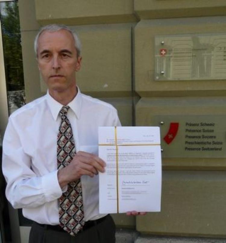 Eric Bachmann, a member of the CIPFG, shows the petition signed by leading politicians before they were handed over to the Swiss Federal Department of Foreign Affairs.  (The Epoch Times)
