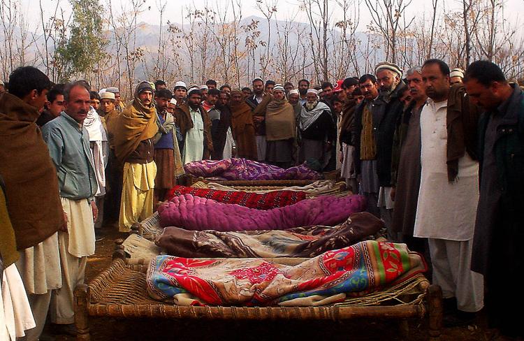 Pakistani people gather beside bodies of people killed when shells destroyed their house, in the Kabal District of the Swat Valley.  (AFP/Getty Images)