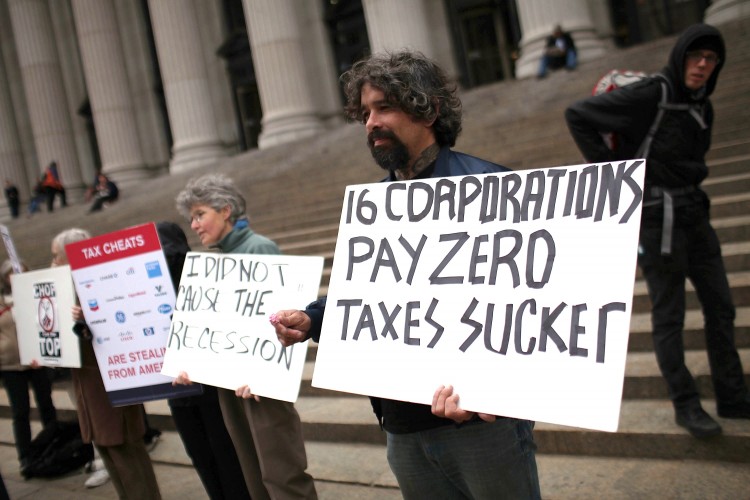 TAXES DEBATED: Protesters against American corporate tax loopholes demonstrate outside of the James A. Farley Main Post Office this past April in NYC. Citizens for Tax Justice analyzed 12 of America's Fortune 500 companies and found that 10 paid no taxe (Spencer Platt/Getty Images)