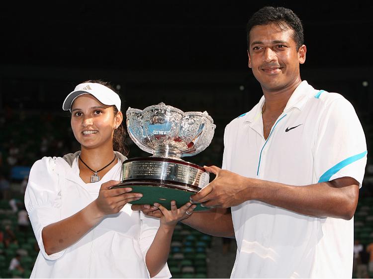 Sania Mirza and Mahesh Bhupathi pose with the championship trophy after winning their mixed doubles final match at Australian Open.   (Robert Prezioso/Getty Images)