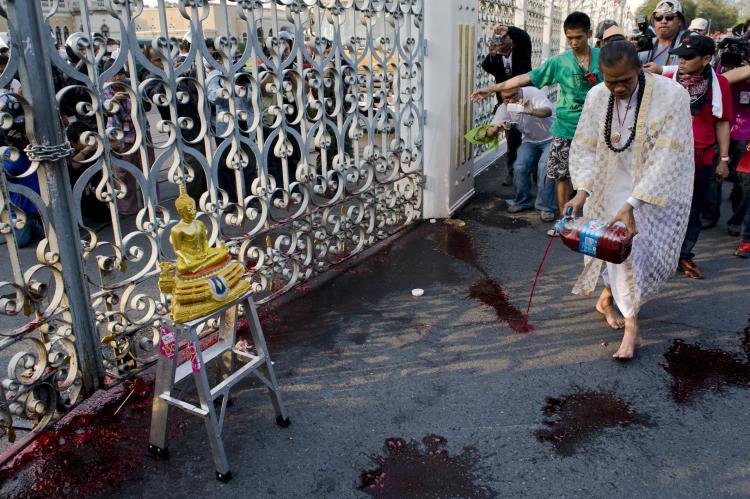 A Brahman pours human blood outside the gate of Thai Government House on March 16 in Bangkok. Masses of protesters, who are supporters of ousted Thai Prime Minister Thaksin Shinawatra, donated their blood for the ceremony, to put more pressure on Prime Mi (Athit Perawongmetha/Getty Images)