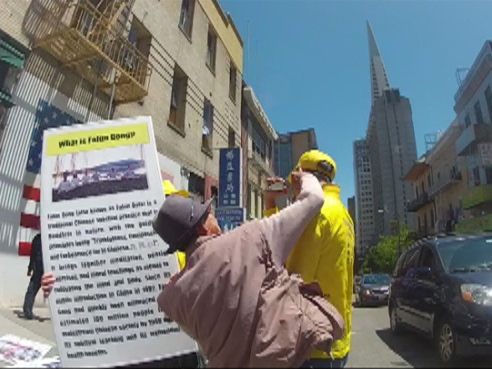 A man delivers a blow to the jaw of Falun Gong practitioner Derek Wang. 