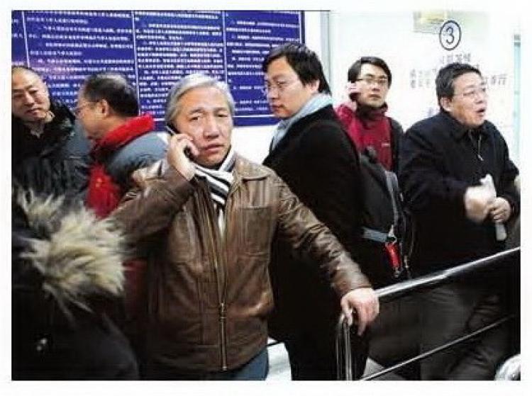 A victim of one of the biggest scandals of official corruption in the Chinese anti-virus industry, the now grey-haired Tian Yakui talks on his cell phone. (Internet photo)