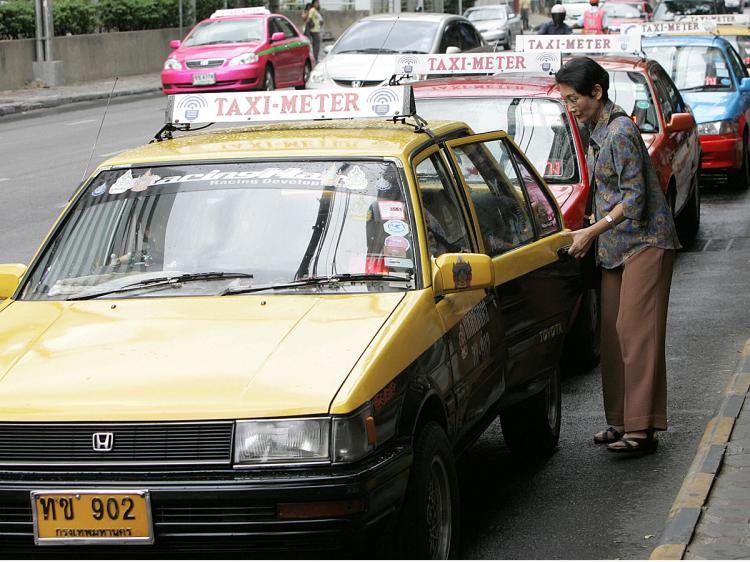 Thai taxi drivers queue while waiting for passengers at a shopping mall, in Bangkok. (Pornchai Kittiwongsakul/AFP/Getty Images)