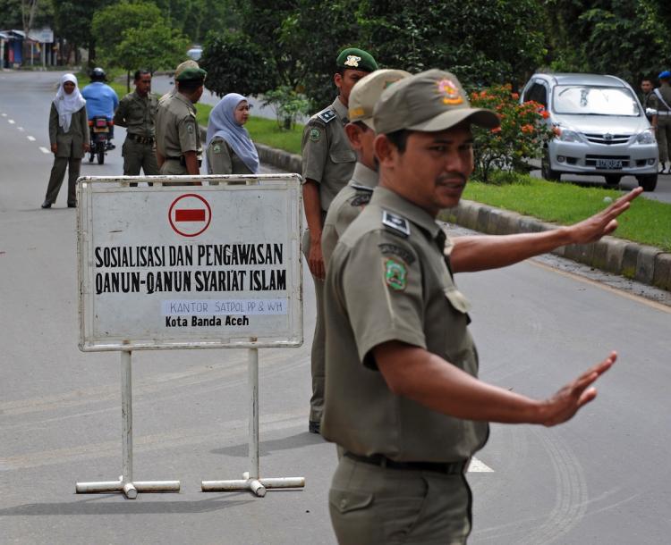 Indonesia Islam police of Aceh sharia manning a checkpoint as they flag down female motorists wearing tight pants and skirts in Dec. 09. Until now the violations have  resulted in only temporary holdings, now they could face weeks of detention.  (Romeo Gacad/Getty Images)