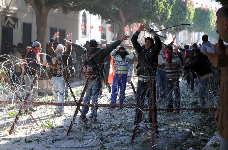 Residents from the central Tunisian region of Sidi Bouzid clash with security forces on January 26, 2011 in front of Prime Minister Mohammed Ghannouchi's office in Tunis.  Tunisia said January 26 it had issued an international arrest warrant for Ben Ali,  (Fethi Belaid/AFP/Getty Images)