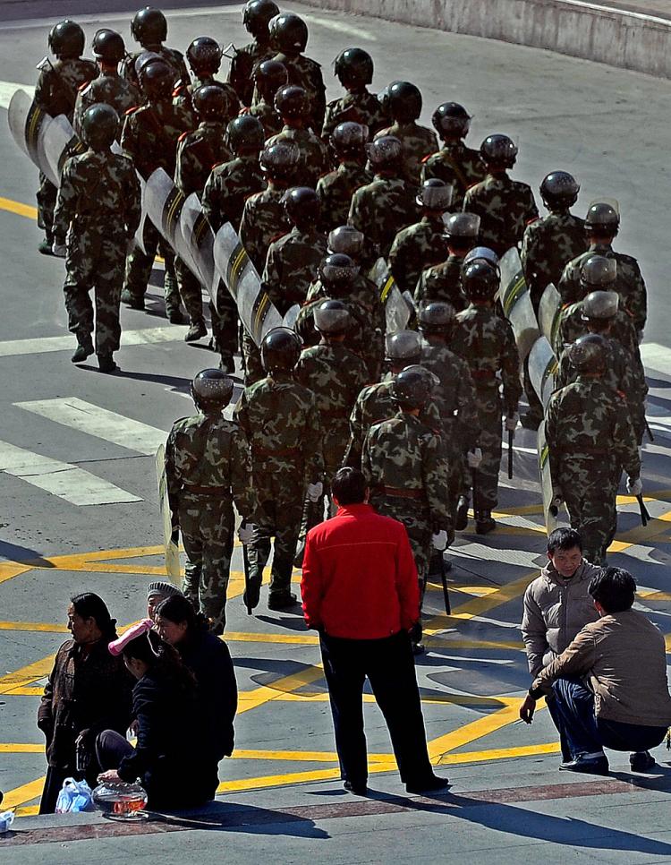 Residents look at Chinese soldiers as they patrol in Kangding county, the capital of Ganzi Tibetan Autonomous Prefecture, in China's southwestern Sichuan province on March 23, 2008.  (Teh Eng Koon/AFP/Getty Images)