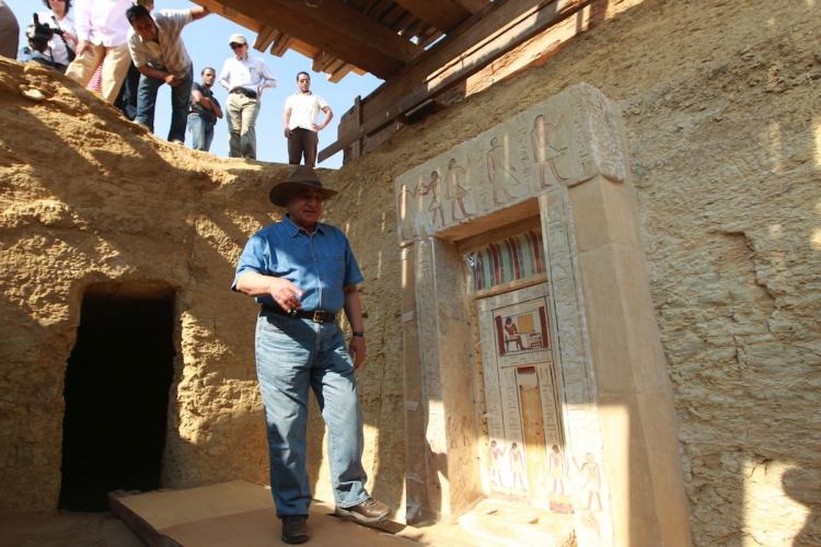 Zahi Hawass, Secretary General of the Egyptian Supreme Council of Antiquities (SCA), walks in front of one of two rock-hewn painted Old Kingdom tombs recently discovered, 20 meters below the ground level in tact, on July 8, at Saqqara necropolis.  (Khaled Desouki/Getty Images)