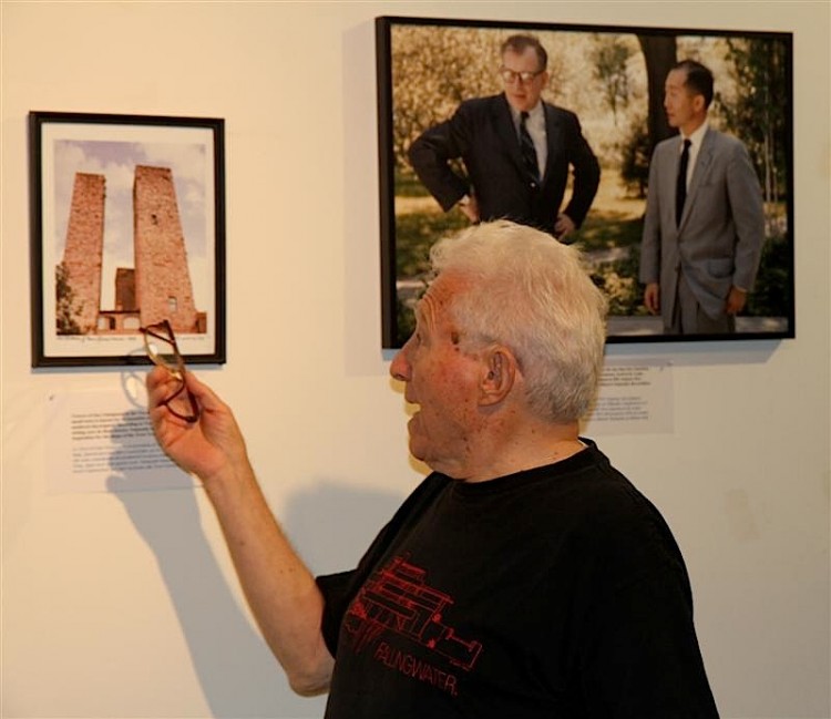 Renowned photographer Tony Vaccaro points at his photograph depicting the inspiration for the Twin Towers design, two medieval 'skyscrapers' in Italy, while the photograph on the right shows Twin Towers architect Minoru Yamasaki (R) and the Finnish-born architect Eero Saarinen (L), who first introduced the two. (Zack Stieber/The Epoch Times)