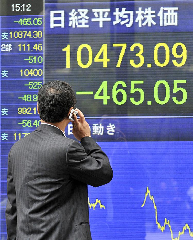 A businessman gazes at a share prices board in Tokyo showing share prices plummeting.  (Yoshikazu Tsuno/AFP/Getty Images)