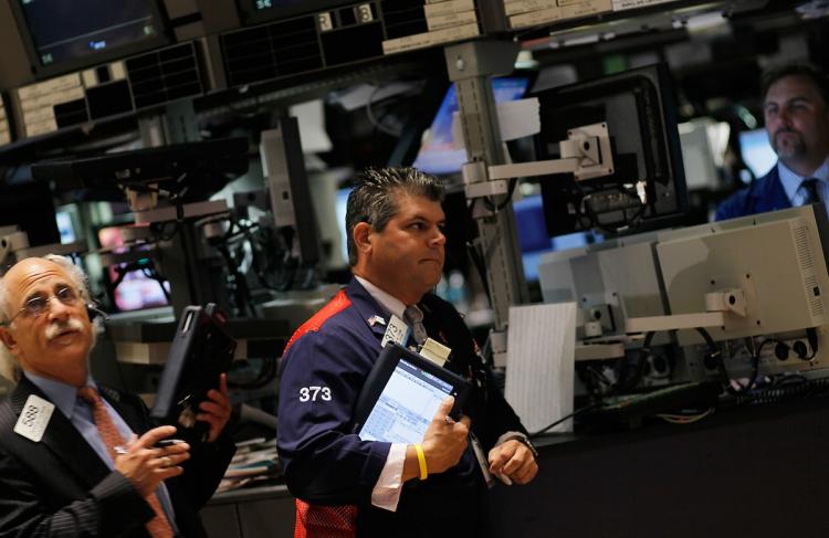 STOCKS RISE: Financial professionals work on the floor of the New York Stock Exchange in New York City. U.S. stocks rose moderately on Monday in the quietest trading day of the year.  (Chris Hondros/Getty Images)