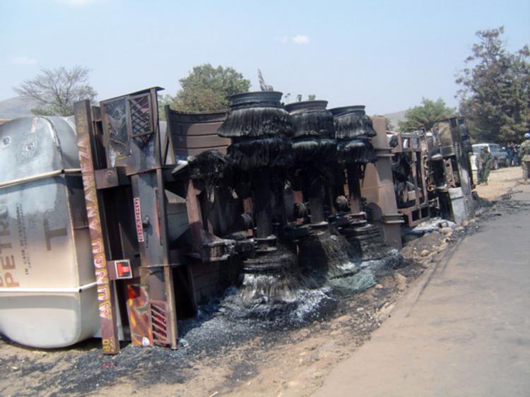 The burnt-out wreckage of an oil tanker lies on its side following an explosion in Sange, Democratic Republic of Congo on July 3. The explosion killed over 200 people and injured over 110.   (STR/Getty Images)