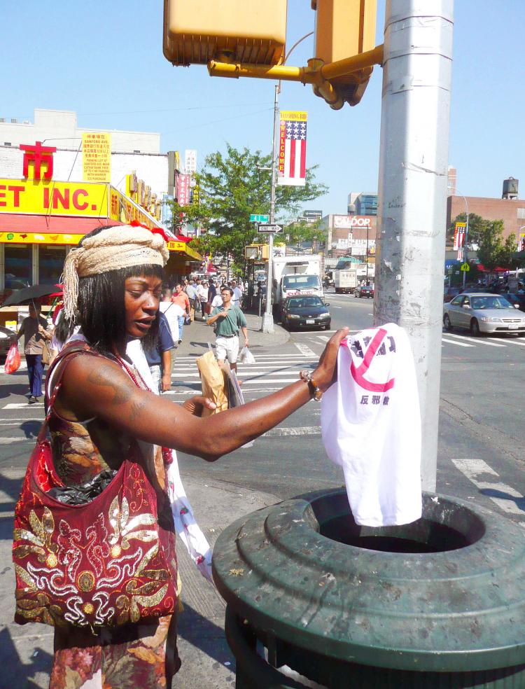 INTO THE TRASH: After discovering a Chinese tee shirt she had been misled into purchasing actually slanders Falun Gong, a resident, who chose to not be named, throws the shirt in the garbage. She had been told that the shirt was for the Olympics. (The Epoch Times)